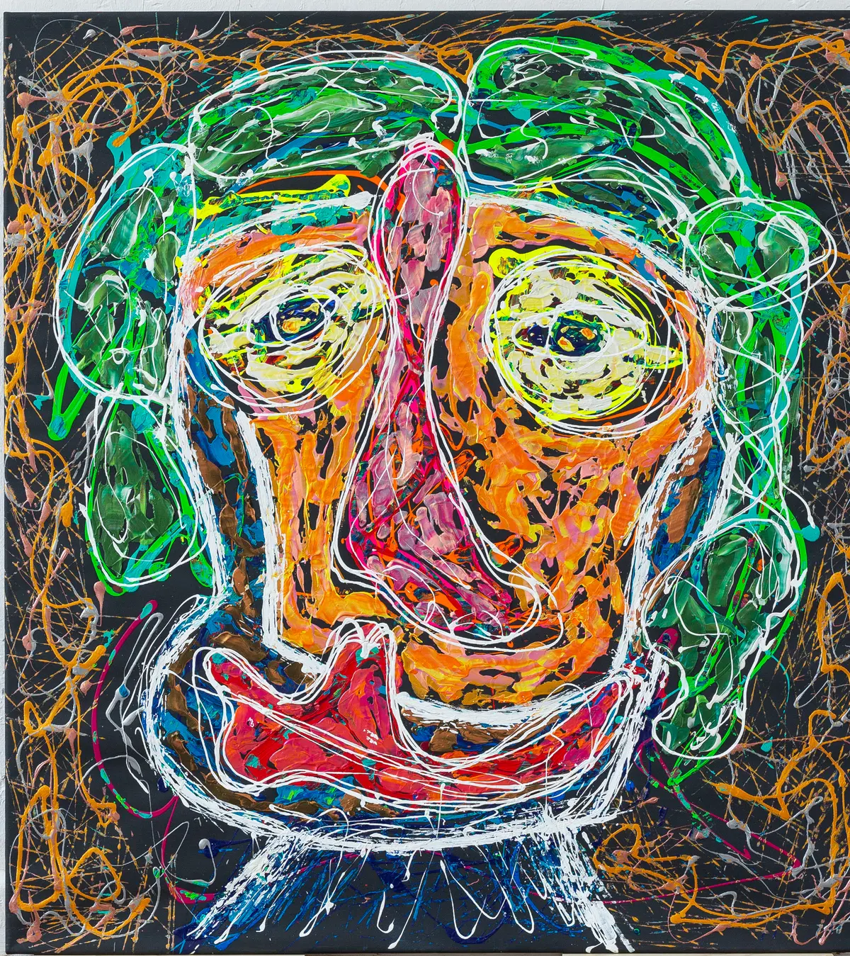 An orange face with green hair and a wide red mouth, outlined in white on a dark ground